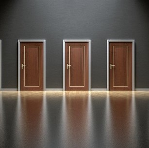 Three identical closed doors. Three identical closed doors.