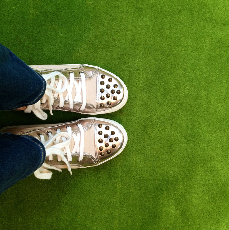 The view from above of some shiny gold sneakers.