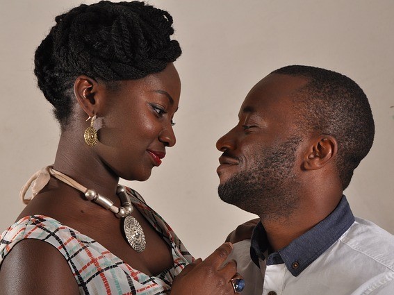A well-dressed and physically attractive couple look lovingly into one another's eyes