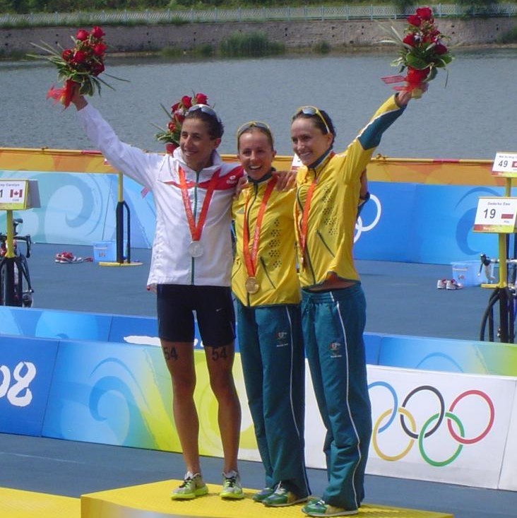 The three medalists in the 2008 Women's Olympic Triathlon stand together on the winner's podium. The three medalists in the 2008 Women's Olympic Triathlon stand together on the winner's podium.